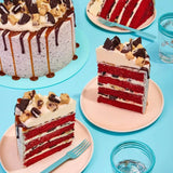 Red Velvet Volcano Cake by Crumbs & Doilies with Oreo crumb icing, cookie dough chunks, and caramel drip.
